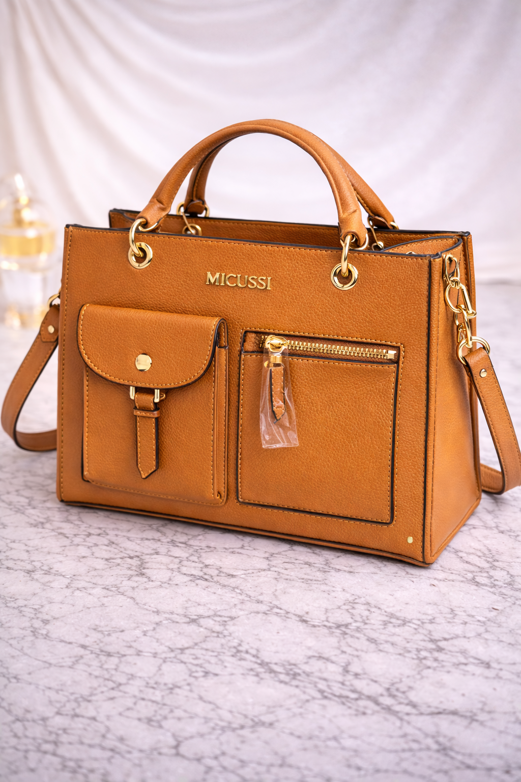 Geantă de damă structurată maro, cu buzunare exterioare și finisaje aurii. Design elegant, piele ecologică premium. Descoperă MEQUEEN.